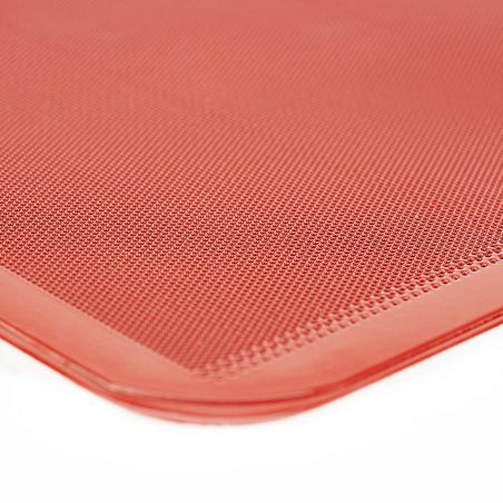 Bandeja lisa perforada de silicona en tono rojo, detalle de textura granular en esquinas.